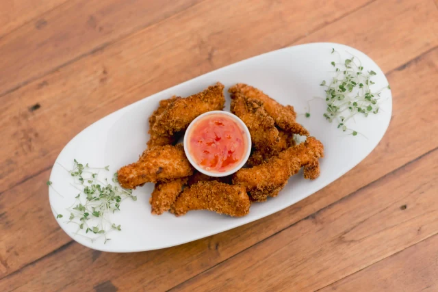 Crispy breaded chicken tenders with sweet chili dip, served at Tèya Beach Restaurant